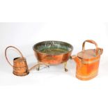 A circular copper planter on three brass feet, 34cm diameter, and two copper watering cans. (3)