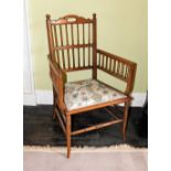 A Edwardian walnut open armchair, with fine spindle turned supports, a padded seat and splayed