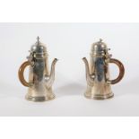 A pair of Edwardian silver chocolate pots, reproduced in the early Georgian manner with hinged lids,