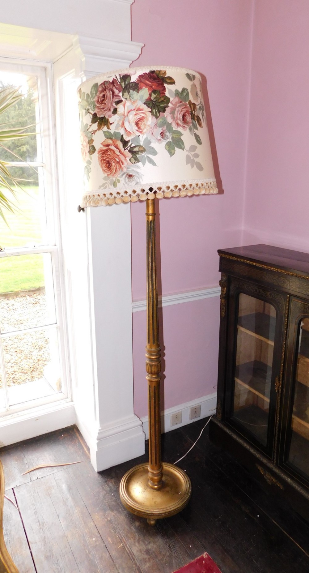 A gilt standard lamp, with a floral shade, a part fluted and leaf carved column with circular