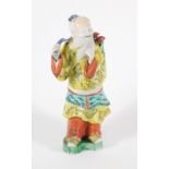 A 19thC Chinese polychrome porcelain figure of a bearded sage, dressed in a yellow robe, 27cm high.