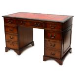A mahogany pedestal desk, the rectangular top with a red leatherette insert, above nine drawers on