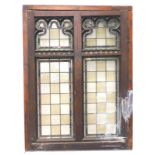 An oak and pine window, inset with stained glass panels, of rectangular form, the tops with Gothic