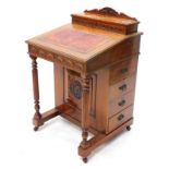 A late 19th/ early 20thC walnut Davenport, the top with a shaped crest and a hinged lid, enclosing a