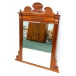 A late 19th/ early 20thC walnut overmantel mirror, with a shaped crest and a rectangular bevelled