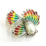 A plique-a-jour fish brooch, set with rubies, marcasite and pearl, with red, green and yellow