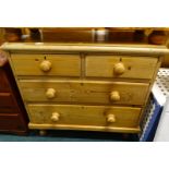 A pine chest of short and two long drawers, with turned wood handles and feet, 83cm wide.