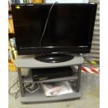 A Toshiba 32 inch LCD TV, a Samsung video recorder, and a stand with remotes.