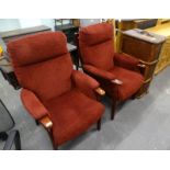 A pair of modern dark red upholstered fireside chairs, with beech frames and a canvas trunk.