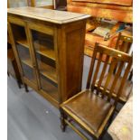 An oak glazed bookcase, on square tapering legs, 98cm wide, and two oak side chairs.