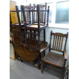 An oak oval drop leaf table, and five chairs, each with barley twist legs and supports, one with