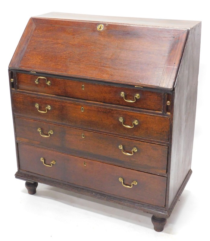 A George III oak bureau, the fall with a moulded edge, enclosing a fitted interior above four