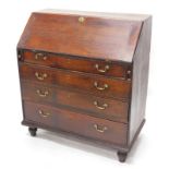 A George III oak bureau, the fall with a moulded edge, enclosing a fitted interior above four