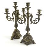 A pair of continental cast brass three branch candelabra, each decorated in rococo style, 35cm