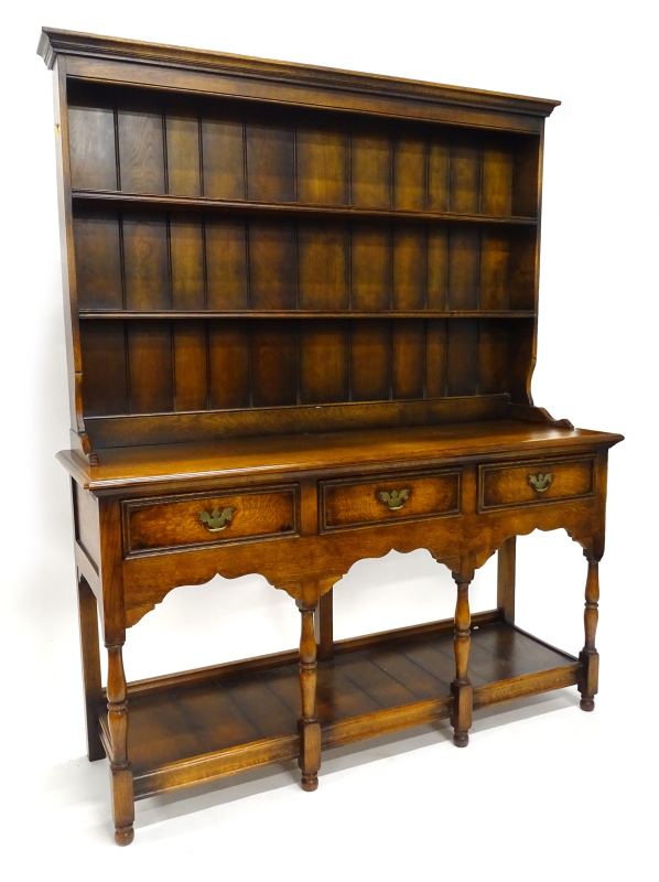 An oak dresser in the late 18thC style, the back with a moulded cornice above two shelves, the