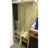 A pair of modern glazed display cabinets, each on a melamine base with glass shelves and lighting,