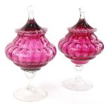 A pair of Victorian style cranberry tinted and clear glass bon bon dishes, each with a tapering lid,