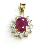 A ruby and diamond pendant, with oval ruby surrounded by round brilliant cut diamonds, white and