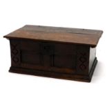 A late 17th/early 18thC oak Bible box, the panelled front carved with bell flowers, on a plinth