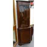 A mahogany bow fronted standing corner cabinet, with single glazed door.