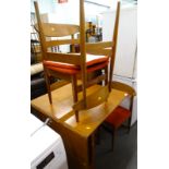 A 1970s teak dropleaf table and four Scandinavian style chairs, each with a padded seat. The