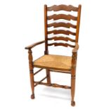 An ash and oak ladder back chair, with a rush seat on turned tapering legs.