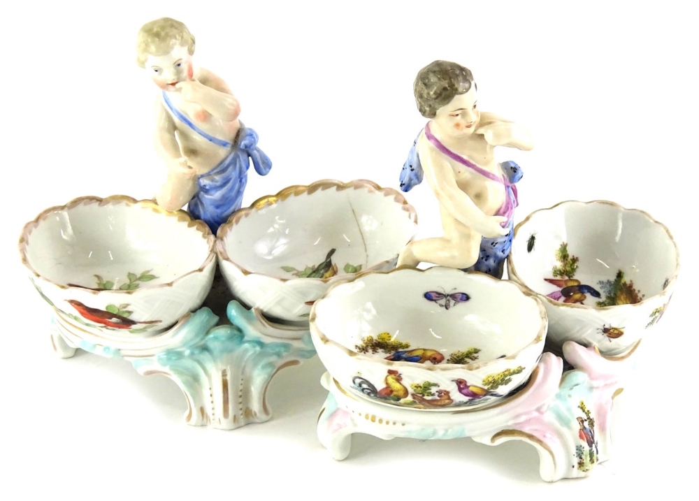 A pair of late 19th/early 20thC Sitzendorf style figural salts, each painted with birds, insects,