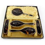 A George V silver and tortoiseshell backed part dressing table set, comprising two hand brushes,
