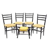 A set of four Italian ebonised ladderback chairs, each with a rush seat, gilt label for Rooksmoor