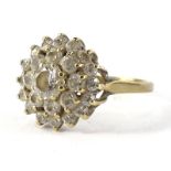 A cubic zirconia dress ring, with layered arrangement of stones, with central stone surrounded by
