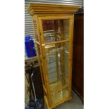 A pine glazed display cabinet with glass shelves, 185cm high, 66cm wide.