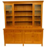 An oak dresser, the top with a moulded edge above an arrangement of three shelves and three drawers,