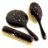 A George V silver and tortoiseshell backed dressing table set, comprising a hair brush, 23cm wide, a