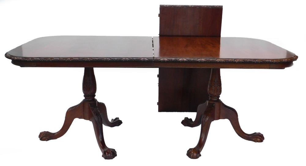 A mahogany two pillar dining table in George III style, the rectangular with rounded corners and a