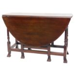 A walnut drop leaf table, the oval top with a moulded edge, on turned supports with Braganza feet,