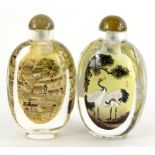 Two similar reverse painted oriental glass snuff bottles, one decorated with storks, the other