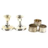 A collection of small silver, to include two silver napkin rings, a pair of silver dwarf candle