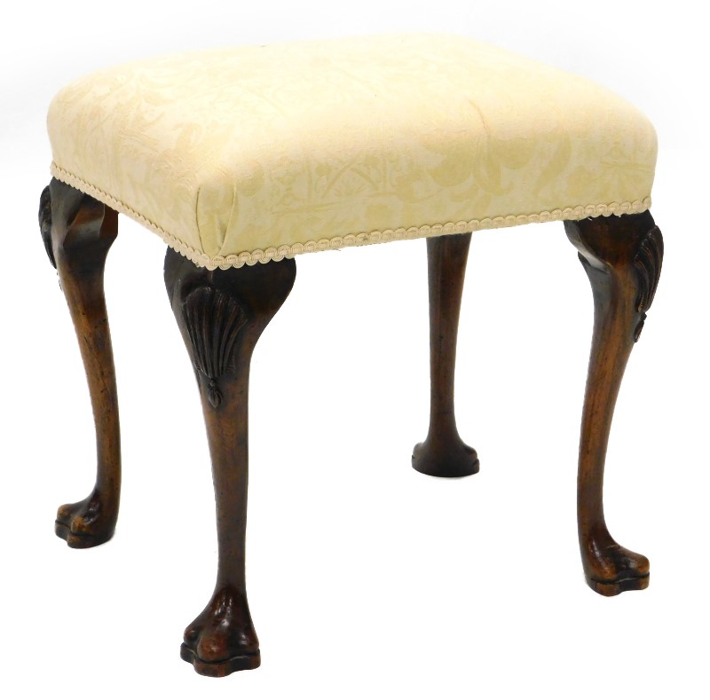 A walnut stool in mid-18thC style, with a padded seat on cabriole legs, carved with shells, etc.,