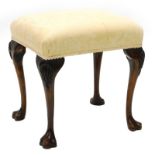 A walnut stool in mid-18thC style, with a padded seat on cabriole legs, carved with shells, etc.,