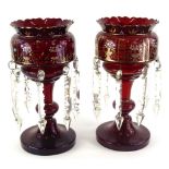 A pair of 19thC ruby tinted glass table lustres, each decorated with gilt vases with flowers,
