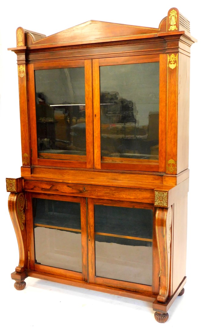 A Regency rosewood and brass cabinet, the top with an arched cornice flanked by lotus and acanthus