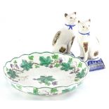 A pair of late Staffordshire type pottery seated cats, each on a blue tapering base, 19cm high,