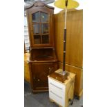A mahogany standing corner cabinet, a standard lamp, bedside table and a bookrack.