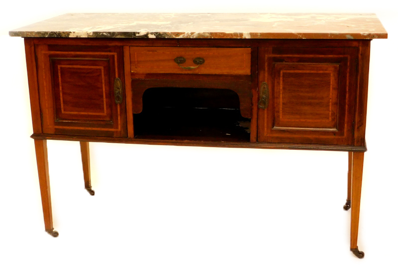 An Edwardian mahogany washstand, with a brown grey and white marble top, above a frieze drawer and a