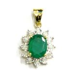 An emerald and diamond pendant, with oval emerald surrounded by tiny diamonds, in yellow metal