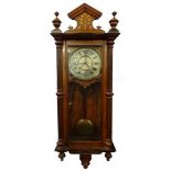 A late 19th/early 20thC Vienna wall clock, in a walnut case with a marquetry crest, the painted dial