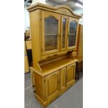 A modern pale beech dresser, with two glazed doors and two panelled doors.