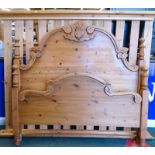 A pine double bed head and foot, carved with leaves, scrolls, etc., the head board 138cm high, 147cm