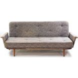 A mid century sofa come day bed, with a sprung metal frame, upholstered in stylised leaf patterned