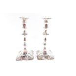 A pair of Edward VII loaded silver candlesticks, of turned form with embossed scroll decoration,